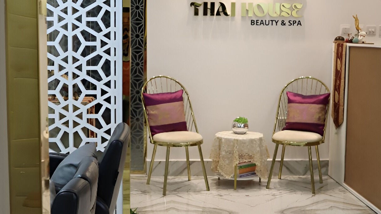 The Thai House reception lounge, with carved wooden panels, orchids and low lamplight